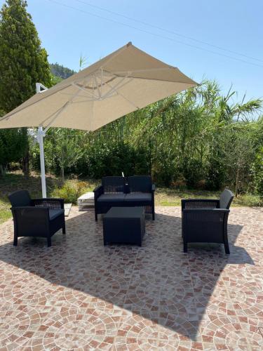 un grupo de sillas y una sombrilla en un patio en B&B Saracinello, en Praia a Mare