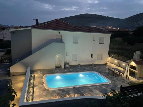 a swimming pool in front of a house at Villa Felicita in Trogir