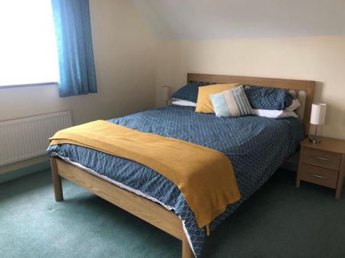 um quarto com uma cama grande e uma cabeceira em madeira em Spacious Detached House with Parking & Views em Fowey