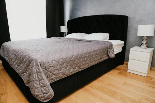 パルヌにあるVesiroos Apartmentのベッドルーム(白い枕の黒いベッド1台付)