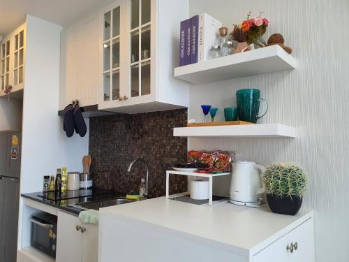 a kitchen with white cabinets and a counter top at Top Flr Seaview & Rooftop Pool @Blu X in Bangsaen