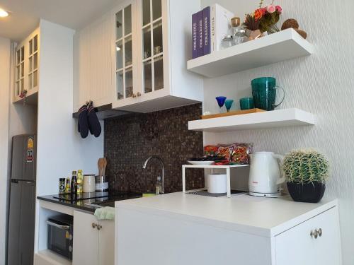 a kitchen with white cabinets and a white counter top at Top Flr Seaview & Rooftop Pool @Blu X in Bangsaen