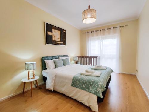 a bedroom with a bed and a couch at Ap Amorosa Praia - 5 minutes From the Beach in Viana do Castelo