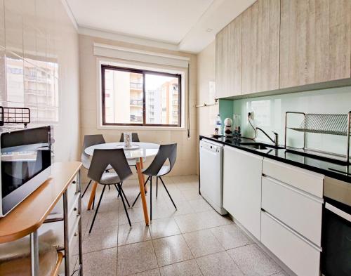 a kitchen with a table and chairs in it at Ap Amorosa Praia - 5 minutes From the Beach in Viana do Castelo