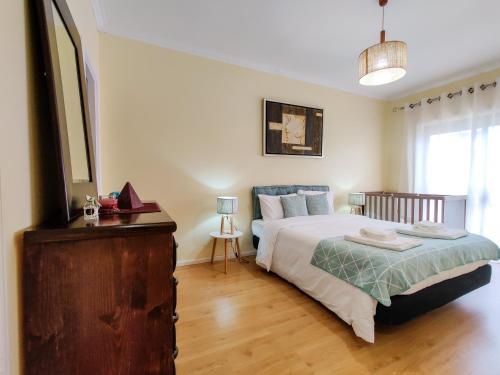 a bedroom with a bed and a dresser in it at Ap Amorosa Praia - 5 minutes From the Beach in Viana do Castelo