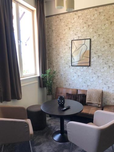 a living room with a table and a couch at Sjugare Gård Bed & Breakfast in Leksand