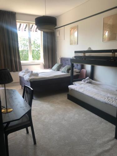 a bedroom with two bunk beds and a table and a chair at Sjugare Gård Bed & Breakfast in Leksand