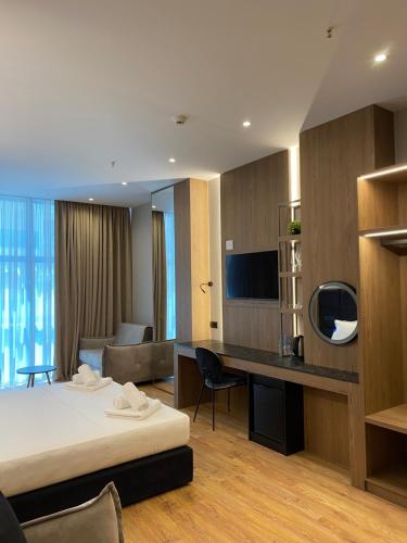 a hotel room with a bed and a desk with a tv at ELMAR HOTEL in Vlorë