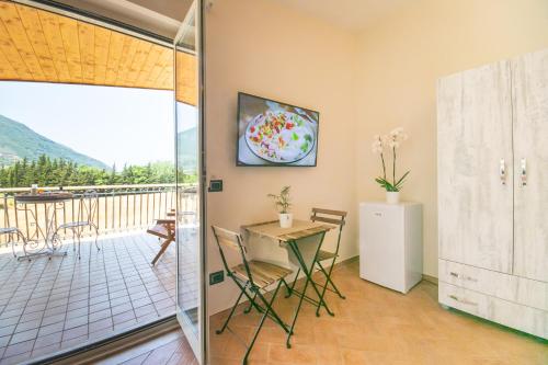 Habitación con mesa, sillas y balcón. en Perla Beach Stabia B&B, en Castellammare di Stabia