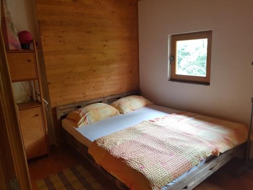 ein kleines Bett in einem Zimmer mit Fenster in der Unterkunft Potok kuca sa bazenom in Konjic