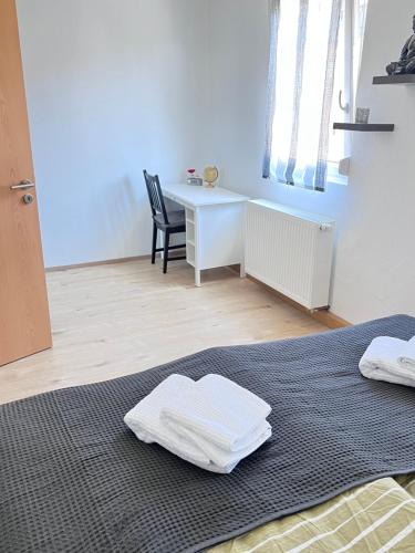 1 dormitorio con escritorio y 1 cama con toallas. en Comfortable new Apartment in #Koblenz# direkt am Rhein en Coblenza