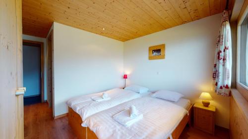 a bedroom with a bed with two white pillows at Chalet des Alpes NATURE & MOUNTAIN by Alpvision Résidences in Prarion