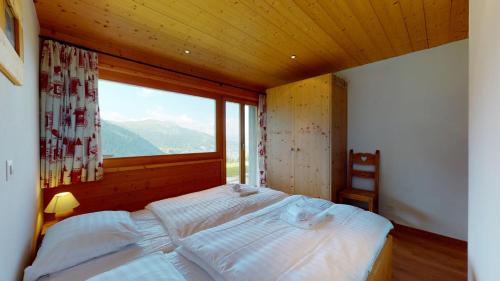 a bedroom with a large bed with a large window at Chalet des Alpes NATURE & MOUNTAIN by Alpvision Résidences in Prarion