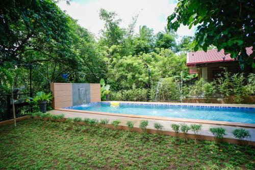 a swimming pool in a yard with a house at Balay Greenika Alfonso Nature Resort in Alfonso