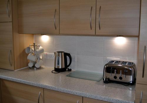 a kitchen counter with a toaster and a coffee maker at Dorcha's Mian in Killin