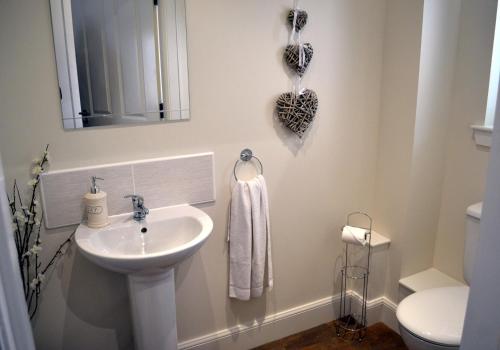a white bathroom with a sink and a toilet at Dorcha's Mian in Killin