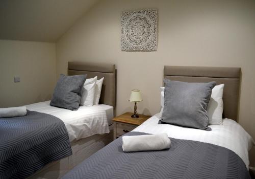 ein Schlafzimmer mit 2 Betten und einem Tisch mit einer Lampe in der Unterkunft Cara Anan in Killin