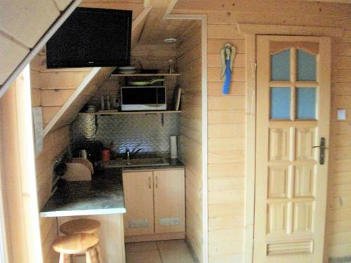 a small kitchen with a staircase in a tiny house at Pokoje ,,Goramiba''Jurgów in Jurgów