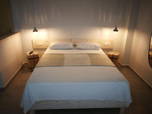 a bedroom with a large bed with two pillows at APARTMENTS BY THE SEA in Gázion