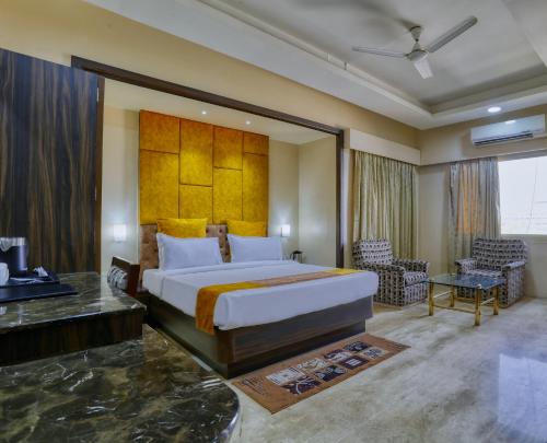 a bedroom with a large bed and a desk at Hotel President in Indore