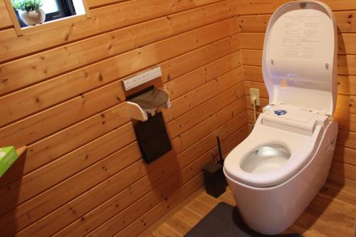 a bathroom with a toilet in a wooden wall at 佐世保VILLA青鹿Ur1 in Sasebo