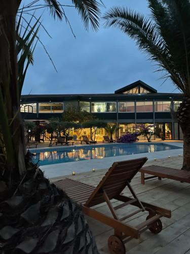 a lounge chair in front of a swimming pool at Tropic Hôtel in Rivesaltes