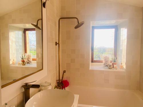 un bagno con vasca, lavandino e specchio di Maison de rêve avec piscine au milieu des vignes a Berrie
