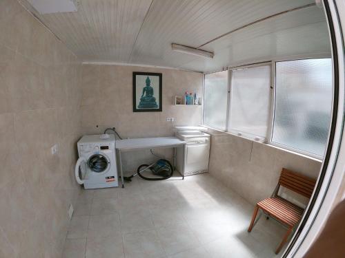 a small bathroom with a washing machine and a window at The Happy House in Mont Barbat