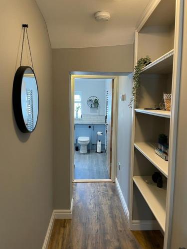 a hallway with a bathroom with a toilet and a mirror at Stunning 1 bedroom Flat in The Mumbles in The Mumbles