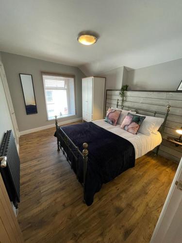 a bedroom with a large bed with a wooden floor at Stunning 1 bedroom Flat in The Mumbles in The Mumbles
