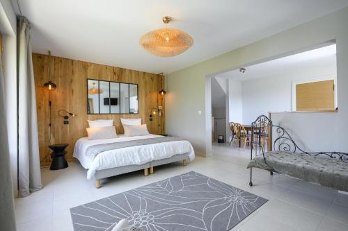 a bedroom with a bed and a table and a couch at Domaine du Bugassou, Chambres, Table d'hôtes & SPA in Belvès