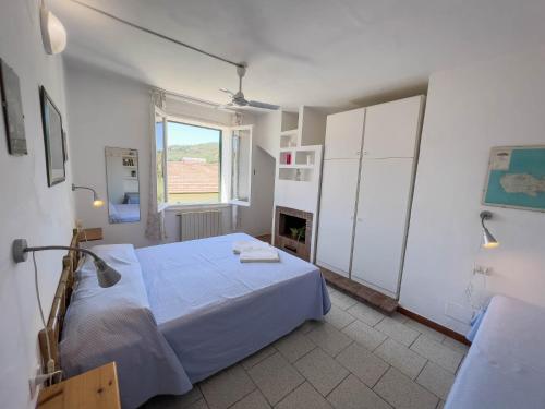 a bedroom with a white bed and a fireplace at Azienda Agricola Sapereta in Porto Azzurro