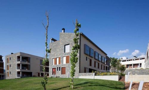 a building with trees in front of it at Margas Golf Apartment in Sabiñánigo