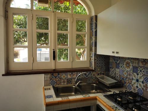 una cucina con lavandino e due finestre di Da Zia Cecilia a Ischia