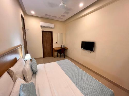 ein Hotelzimmer mit einem Bett und einem TV in der Unterkunft Hotel Mithila Residency Noida - Couple Friendly Local IDs Accepted in Noida