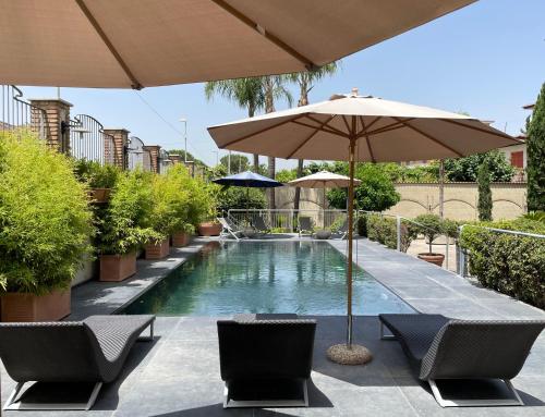 uma piscina com duas cadeiras e um guarda-sol em Hotel Casal Dell'Angelo em Marigliano