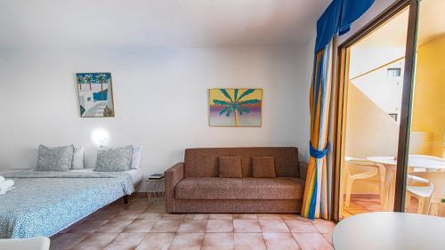 ein Zimmer mit einer Couch und einem Bett und einem Tisch in der Unterkunft Estudio castle harbour 403 los Cristianos in Los Cristianos