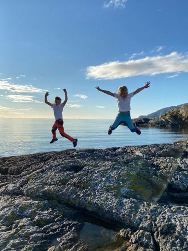 a woman jumping in the air over the water at Torvholmen in Fosnavåg