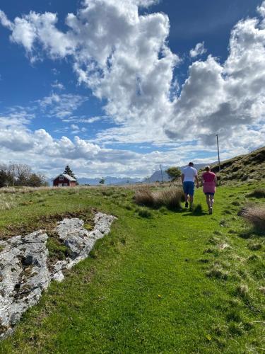 two people walking down a grassy hill at Torvholmen in Fosnavåg