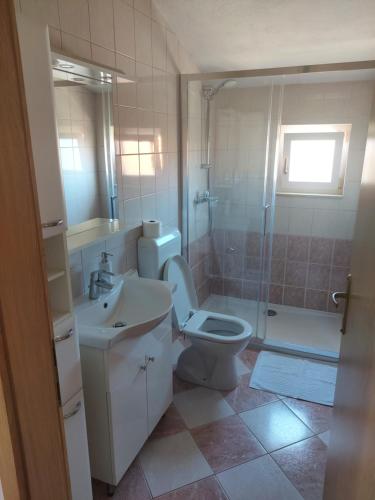 a bathroom with a toilet and a sink and a shower at Apartments Prgin in Primošten