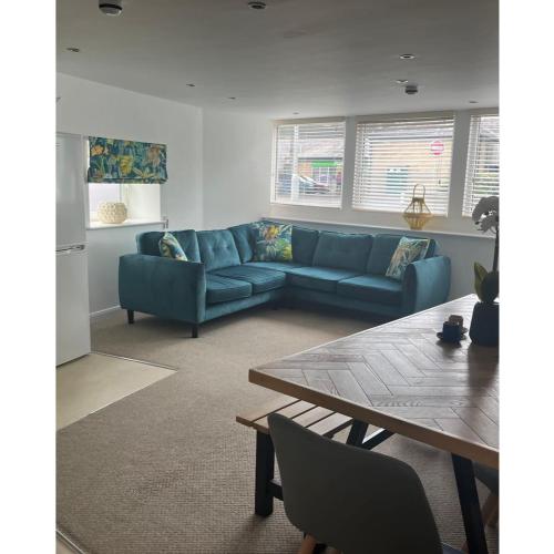 a living room with a blue couch and a table at The Hideout (Garden Flat, 4 Dragon Road) in Harrogate