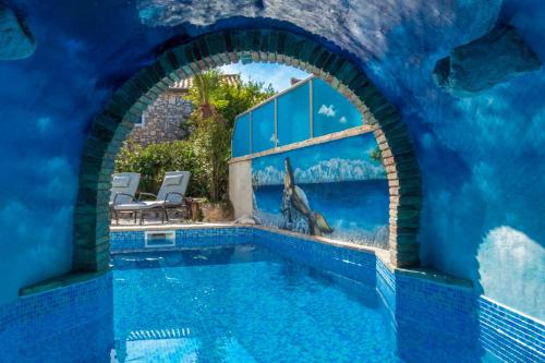 a swimming pool in a house with a blue wall at Villa Dunatić in Županje