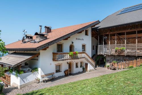 a large white building with a roof at Schildberghof Schlernblick in Siusi