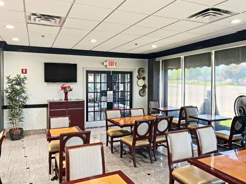 a dining room with tables and chairs and a tv at Quality Inn & Suites Cincinnati Downtown Area in Cincinnati