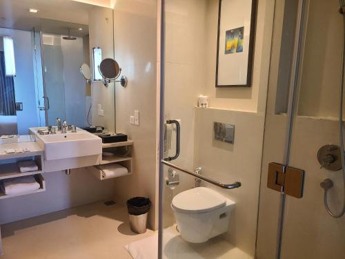 a bathroom with a toilet and a sink and a shower at Novotel Hyderabad Airport in Hyderabad