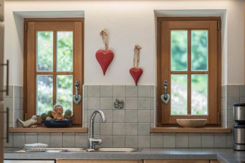a kitchen with two windows with hearts on the wall at Thaleralm in Obereggen