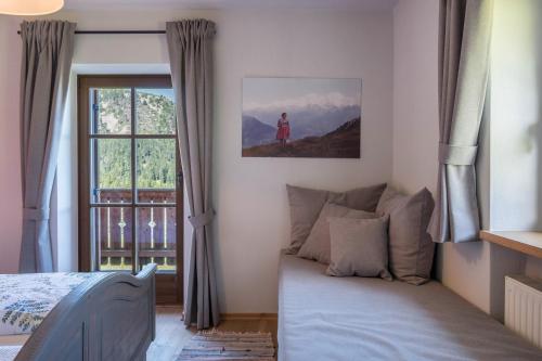 a bedroom with a bed and a window at Thaleralm in Obereggen