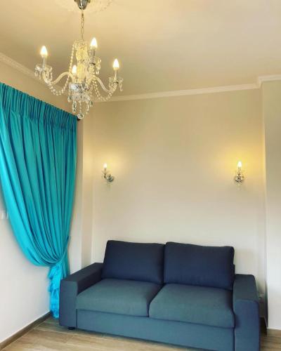 a living room with a blue couch and a chandelier at Villa Ulyana Sarti - Ancient Greece in Center in Sarti