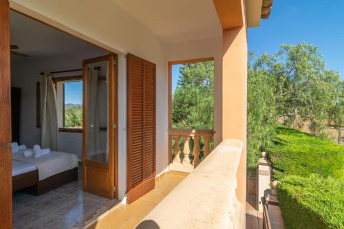 a room with a balcony with a bed and a window at Pili in Felanitx