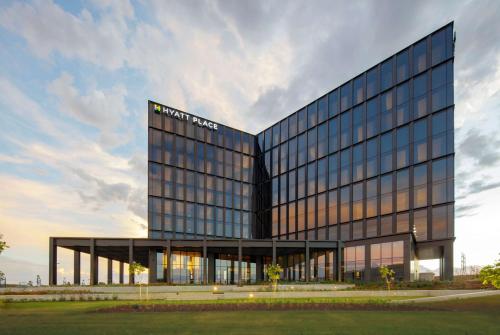 a tall glass building with a sign on it at Hyatt Place Melbourne Caribbean Park in Scoresby